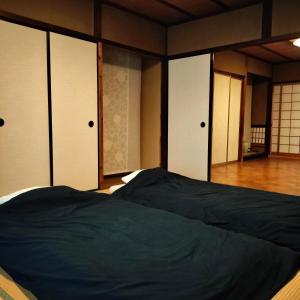 衣笠にあるVilla near Kinkakuji 金閣寺周辺 貸切町屋 無料駐車場 ベンツ貸出 Pets OKのドアとベッドのある寝室