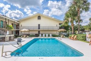 a pool in front of a house with palm trees at Days Inn by Wyndham Lake Park/Valdosta in Lake Park