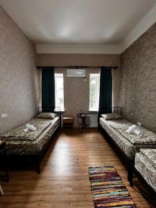 a room with two beds and a table at City center house in Kutaisi