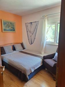 un dormitorio con dos camas y un sofá en Apartman Mari, en Trogir