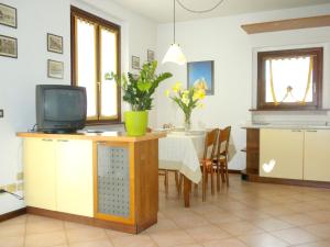 a kitchen and dining room with a table and a television at Retreat at Via Toscanini in Lazise