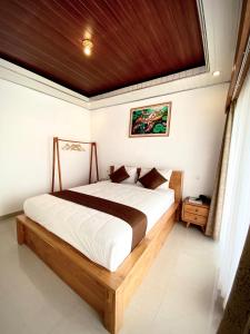 库布盼洛坎senja bali kintamani的卧室里有一张带木质床头板的大床