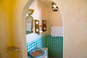 bagno con servizi igienici, lavandino e specchio di Kasbah Rose a Tangeri