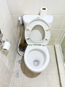 a bathroom with a toilet with a roll of toilet paper at 1 BR Comfy & Premium Entire Apt By Deeta Living in Jakarta +48 photos