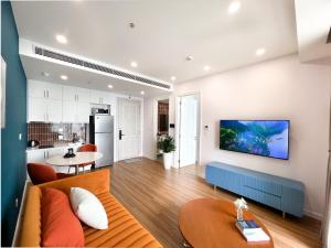 a living room with a couch and a kitchen at Sunset Town Apartments Free Gym & Pool in Phu Quoc