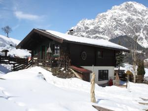 a house in the snow with a mountain in the background at Chalet in Leogang near Ski Slopes in Leogang