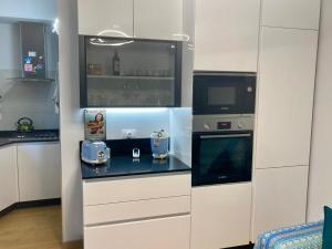 a kitchen with white cabinets and a counter with a microwave at Sara’s Home in Turin +11 photos