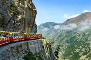 a train is traveling down a mountain cliff at Maison Paisible au coeur des Pyrénées in Igon