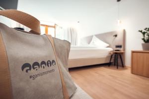 a tote bag sitting on a chair in a bedroom at Ganischgerhof Mountain Resort & Spa in Nova Ponente