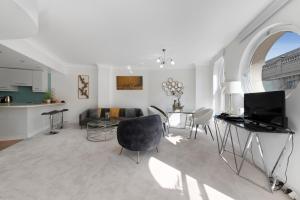 a white living room with a couch and a table at 3 Bedroom Penthouse with Roof Terrace in Covent Garden in London