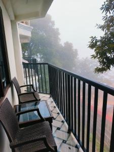 two chairs and a table on a balcony at HOTEL HOLIDAY PLAZA DALHOUSIE - Near Ghandhi Chowk Mall Road in Dalhousie