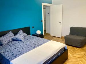 a blue bedroom with a bed and a chair at Sara’s Home in Turin
