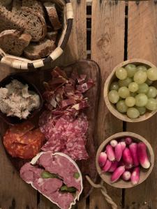 a table with baskets of grapes and meat and bread at Le Mas Bastide in Gaudonville