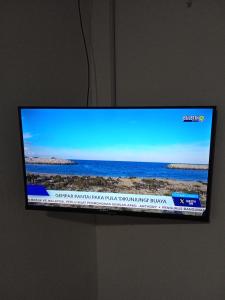a flat screen tv sitting on top of a wall at Guest House 2 in Kuala Terengganu