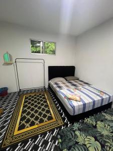 a small bedroom with a bed and a rug at Guest House 2 in Kuala Terengganu