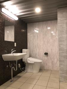 a bathroom with a sink and a toilet and a mirror at ホテルバリビーチ in Miyaki