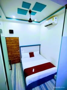 a small bedroom with a bed and a ceiling at royal guest house and dormitory in asalpha in Mumbai