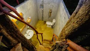 a bathroom with two urinals and a sink and a toilet at Farming Tree House in Sigiriya