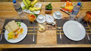 a wooden table topped with plates of food and drinks at Farming Tree House in Sigiriya