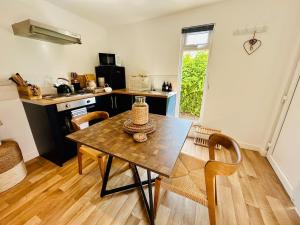 a kitchen with a wooden table and chairs in a room at The Wee Retreat in Cameron