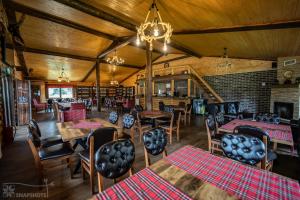 a restaurant with wooden ceilings and tables and chairs at CLUBUL DACILOR in Comandău