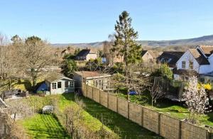 a fence in front of a yard with houses at South Downs home in Ditchling
