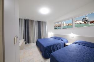 ein Hotelzimmer mit zwei Betten und einem Fenster in der Unterkunft M9 Rest House Venice in Venedig