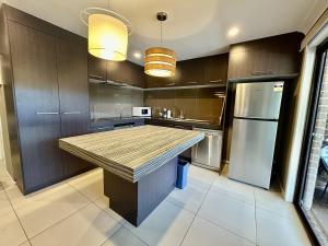 a kitchen with a large island in the middle at Enjoy your Private Pool between BNE and Gold coast in Tanah Merah +1 photo