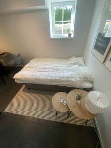 a small bedroom with a bed and two tables at Newly renovated apartment close to city center in Oslo
