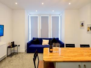 Una sala de estar con un sofá azul y una mesa. en Pass the Keys Llandaff - Modern Bright Central wParking, en Cardiff