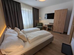 a hotel room with two beds and a desk at Heuriger und Gästezimmer Schmidt in Hagenbrunn