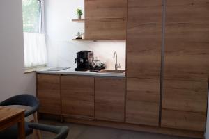 a kitchen with wooden cabinets and a sink at Heuriger und Gästezimmer Schmidt in Hagenbrunn +7 photos
