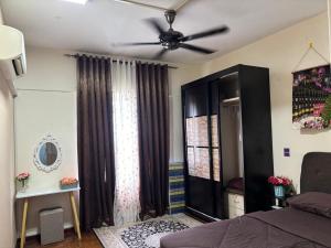 a bedroom with a ceiling fan and a window at Amaryllis guest house PD in Port Dickson