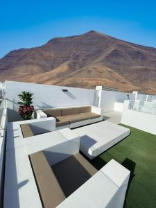 une maison blanche avec un canapé sur le toit dans l'établissement Villa Julieta Lanzarote, à Playa Blanca
