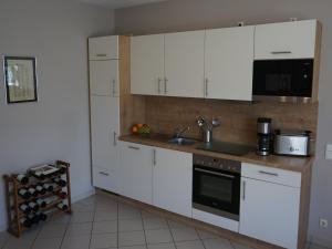 a kitchen with white cabinets and a sink and a stove at Romantischer Aufenthalt mit Blick auf den Weinberg in Kinheim +23 photos