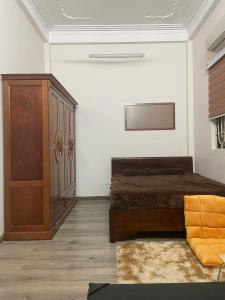 une chambre avec un lit et une armoire en bois dans l'établissement Cozy Fam Homestay - 100 Ngõ 318 Đê La Thành, à Hanoï