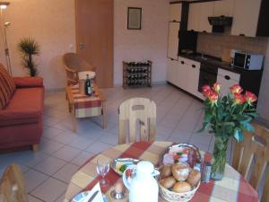 a living room with a table with a vase of flowers at Vineyard View Romantic Stay in Kinheim +21 photos
