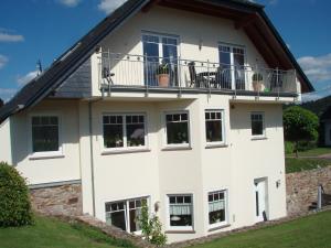 a white house with windows and a balcony at Vineyard View Romantic Stay in Kinheim