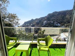 a balcony with a table and chairs and a view of a mountain at The Boho Mussoorie in Mussoorie +19 photos