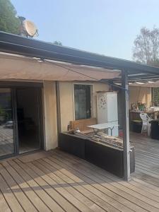 an outdoor patio with a deck with a refrigerator at Brigitte Carbonnel in Aydat +4 photos