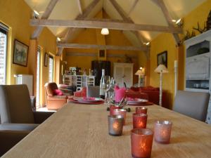 a dining room with a wooden table and a living room at Cozy Family Home in Oostkamp in Rijsberge