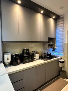 a kitchen with white cabinets and a counter top at Ris Homestay Islam FOREST HEIGHT in Seremban