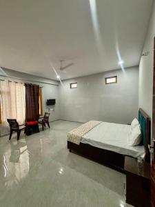 a bedroom with a bed and a table and chairs at AAAC Rooms in Sundarnagar