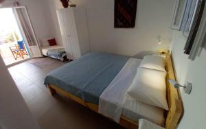 a bedroom with a large bed and a balcony at Στούντιο 1 in Donoussa