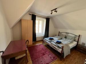 Un dormitorio con una cama y una mesa y una ventana. en Charmettes, en Neuchâtel