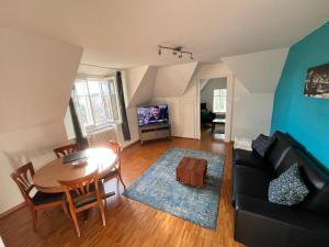 una sala de estar con una mesa y un sofá en Charmettes, en Neuchâtel