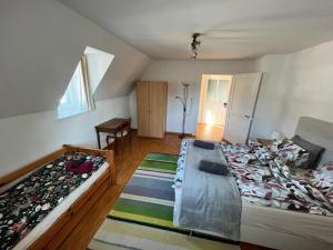 Un dormitorio con dos camas y una mesa dentro. en Charmettes, en Neuchâtel 1 foto más