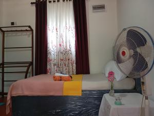 a room with a bed with a fan and a table at Great escape ella in Ella