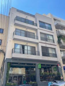 Un edificio blanco con balcones a los lados. en Family Flat in San Gwann, en San Ġwann
