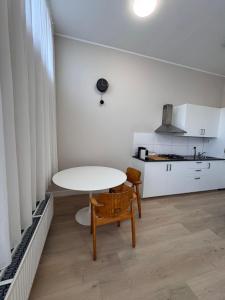 ein weißer Tisch und Stuhl in einem Raum mit Küche in der Unterkunft Getferweg 50-2 City Appartement in Enschede + 3 Fotos